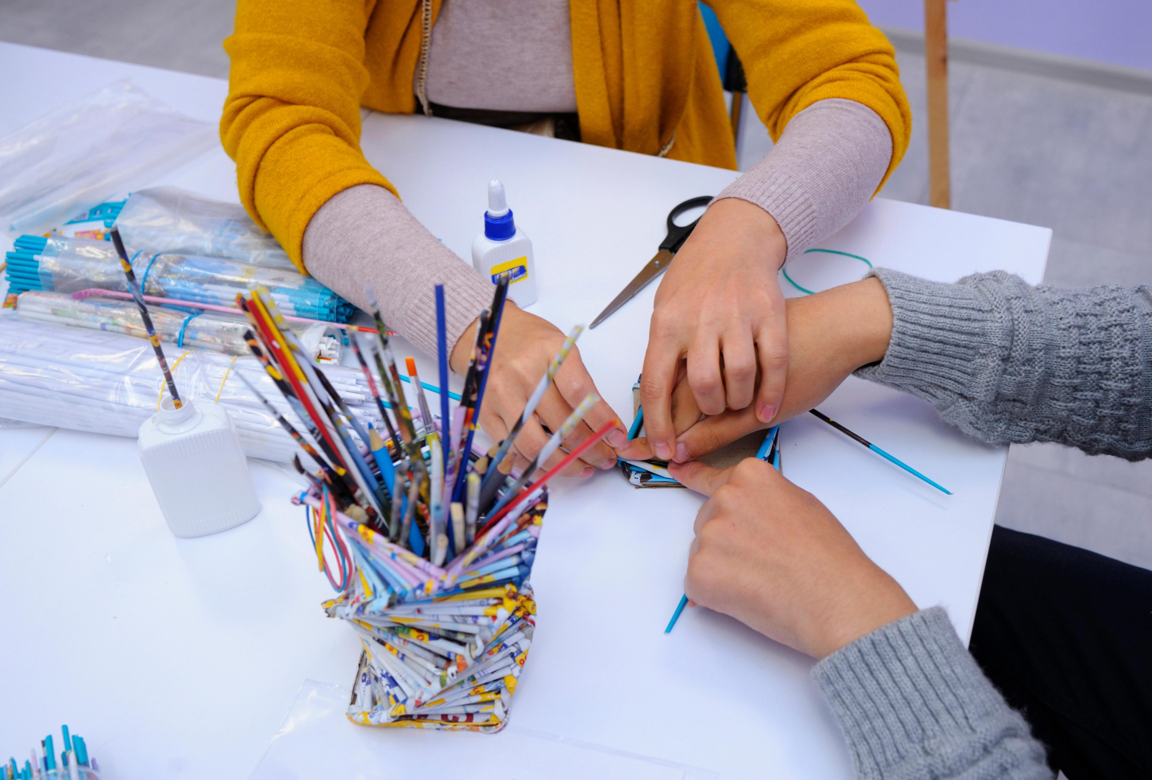 Teacher helping student with craft